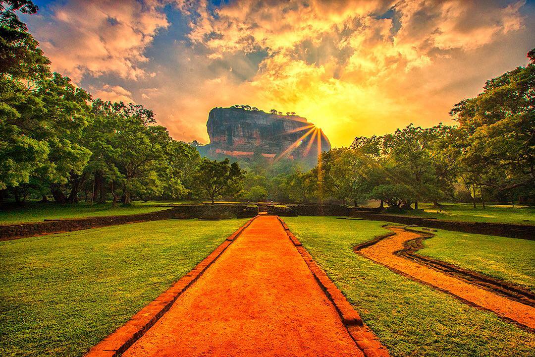 The early morning sun peaks around the Sigiriya Lion Rock Fortress in the central plains of Sri Lanka.⠀
⠀
One of the most dramatic sights in Sri Lanka, the ruins of the iconic fortress, sit atop near-vertical walls that rise almost 200 metres (660 ft) above the surrounding forests. The site was selected by King Kasyapa (477 – 495) to be his capital city. He built his palace on the top, carved from bedrock and decorated its sides with colourful frescoes. ⠀
⠀
Have you visited Sri Lanka? What was your favourite sight?⠀
⠀
#bbctravel #Sigiriya #SigiriyaRock #LionRock #SriLanka #rock #Ancient #parque #NumberGuessing #lka #Lanka #ceylon #IndianOcean #ocean #srilankaecotourism #travel #sunset #sunrise #travelgram #wanderlust #instatravel #adventure #view #travelphotography