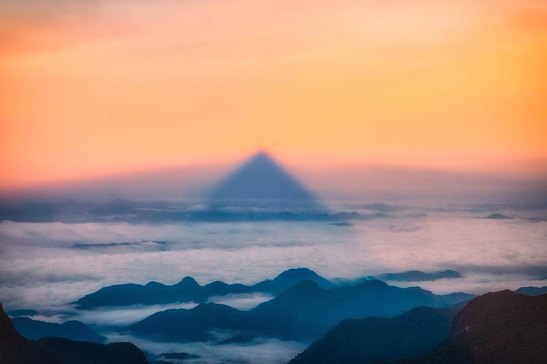 The unique pyramidal shadow cast by Sri Pada (Sacred Footprint) AKA Adam's Peak in Sri Lanka, on the surrounding horizon during our #sunrise pilgrimage to the summit. ⠀
⠀
The mountain is 2,243m (7,359ft) tall and has a distinctive conical shape to it, hence the unusual (almost mystical) shadow it creates. The mountain is significant to a number of religions including Buddhism, Hinduism and Christianity with the pilgrimage season beginning on poya day in December and running until Vesak festival in May. ⠀
⠀
#adamspeak #nature #world #WonderOfAsia #voyage #tree #pilgrimage #SriLanka #lka #Lanka #ceylon #IndianOcean #ocean #beach #srilankaecotourism #travel #sunset #travelgram #wanderlust #vacation #instatravel #adventure #view #travelphotography