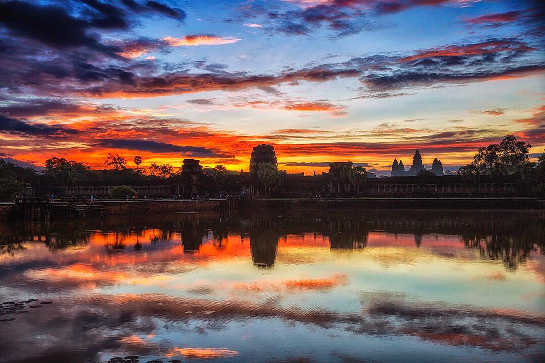 A wider shot of Angkor Wat in Cambodia at #sunset. A few tourists are still milling around as the sun drops behind the largest religious structure ever built. 
Known as Angkor Wat (City Temple), the site measures a massive 1,626,000m2 (162.6 hectares) and was built by the Khmer King Suryavarman II from 1113-50 to honour the Hindu god Vishnu. 
The Cambodian flag depicts the main building of Angkor Wat. Together with the flag of Afghanistan, it holds the distinction of being one of only two state flags to feature a building.

#angkorwat #Cambodia #siemreap #travel #umeda #izakaya #Temple #Angkor #SooriyaVarman #PhnomPenh #khmer #Asia #angkor #templesofangkor #sunrise