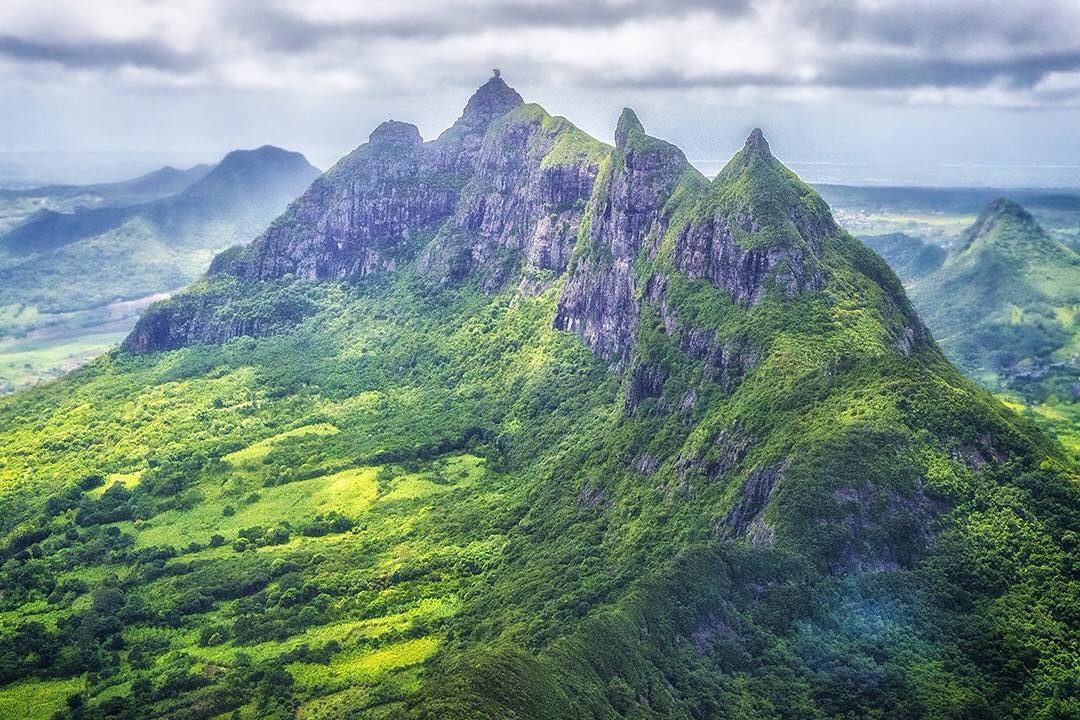 The incredible view across the Moka Range of mountains from Le Pouce (The Thumb) in Mauritius.⠀
⠀
The hike to the top of Le Pouce provides an unrivalled panoramic view of the entire island. Even on an overcast day you can see the northern islands, Le Morne on the south coast, the capital city of Port louis and, of course, the incredibly dramatic peaks of the Moka Range. The dark rolling clouds only add to the atmosphere. The mountain is named Le Pouce because of its thumb-shaped peak. ⠀
⠀
A volcanic eruption millions of years ago left behind the island’s jagged assortment of peaks. Charles Darwin also once climbed the Thumb. The scientist/explorer made his own visit here in 1836.⠀
⠀
It takes about two hours to climb and another hour to descend the mountain. It's worth pausing just below the peak to enjoy this stunning vista. We climbed it during our stay at @beachcomber_hotels as the trail can be easily accessed from anywhere on the island. ⠀
⠀
#LePouce #MokaRange #Moka #Mauritius #travel #ilemaurice #beach #Africa #Indian #BeachcomberExperience #indianocean #paradise #islandparadise #wanderlust #igersmauritus #sky #amazing #summertime #nature #mountains #view