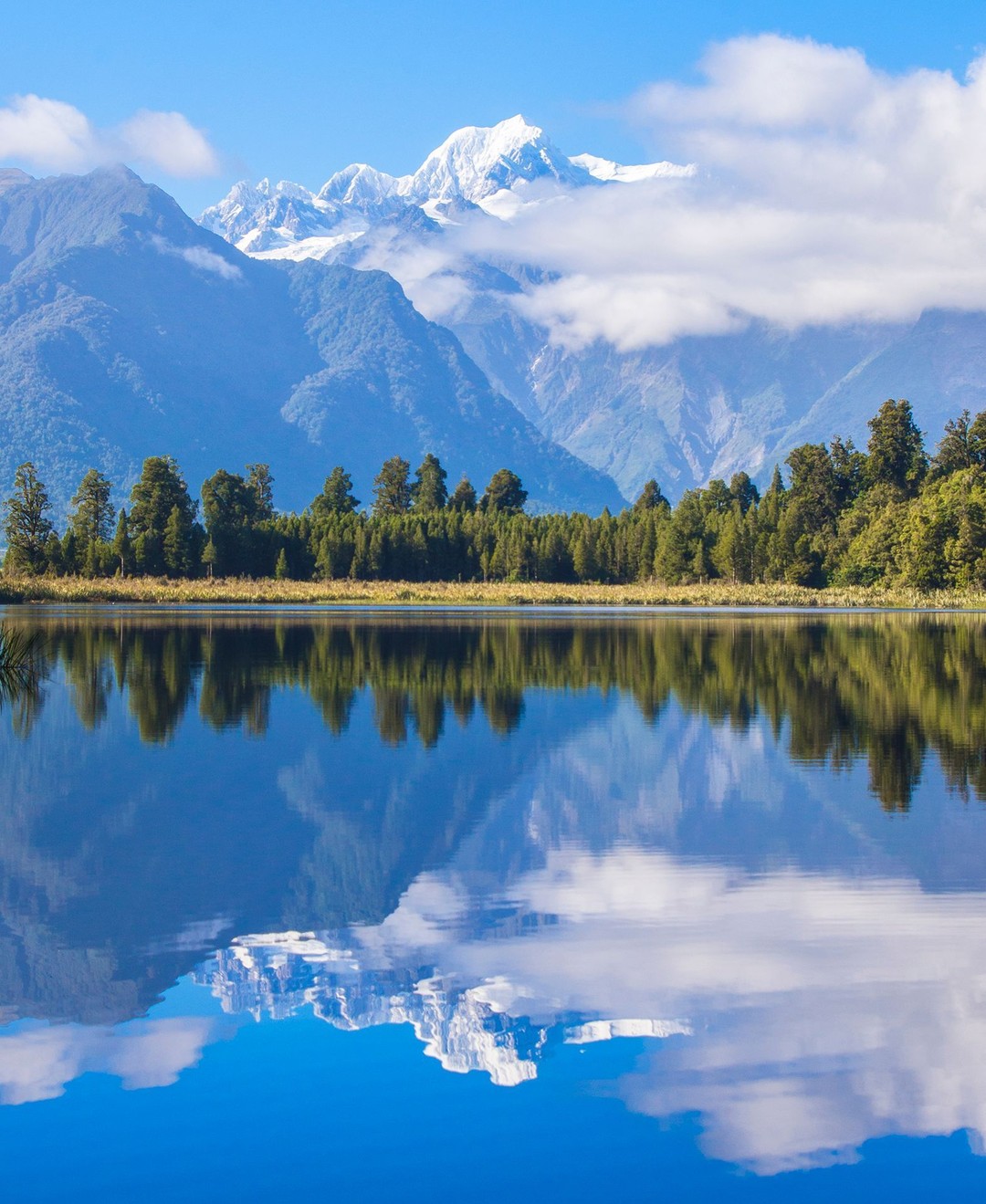 A postcard perfect view across Lake Matheson greets us on @purenewzealand's South Island during our tour of the island with @gadventures and @lonelyplanet. 
New Zealand's highest and second highest mountains – Aoraki / Mount Cook and Mount Tasman – can be seen rising above the still waters of Lake Matheson. 
Mount Tasman at 3,497m (11,473ft) is New Zealand's second highest mountain, while Aoraki / Mount Cook is its highest at 3,724m (12,218ft).
-⠀
-⠀
-⠀
-⠀
-⠀
-⠀
#Aoraki #MountCook #mountcooknz #MountTasman #MtCook #SouthernAlps #Matheson #LakeMatheson #foxglacier #mountcooknationalpark #southislandnewzealand #southisland #southislandnz #newzealand #NZMustDo #RealMiddleEarth #NZ #visitnewzealand #lppathfinders #gadventures #liveoutdoors #bestintravel #thegreatoutdoors #wellhiked #takeahike #hikingadventures #getoutstayout #ig_newzealand #newzealandguide