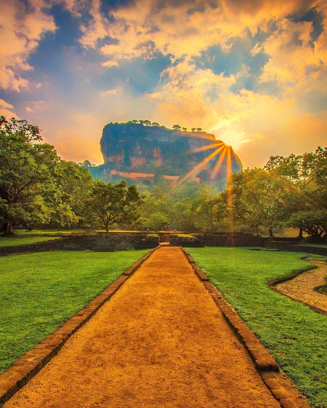 The morning sun takes its first peek around Sigiriya Lion Rock Fortress in the central plains of Sri Lanka – no.1 on @lonelyplanet's #BestinTravel list of top countries to visit in 2019.⠀⠀
⠀⠀
One of the most dramatic sights in @destination_srilanka, the ruins of the iconic fortress, sit atop near-vertical walls that rise almost 200m (660ft) above the surrounding forests. The site was selected by King Kasyapa (477–495) to be his capital city. He built his palace on the top, carved from bedrock and decorated its sides with colourful frescoes. ⠀⠀
-⠀
-⠀
-⠀
-⠀
-⠀
-⠀⠀
#SoSriLanka #VisitSriLanka #Sigiriya #SigiriyaRock #sigiriyarockfortress #LionRock #srilanka  #srilankadaily #srilankatravel #lka #Lanka #ceylon #IndianOcean #ocean #srilankaecotourism #nakedplanet #wonderful_places #exploretocreate #liveoutdoors #neverstopexploring #keepitwild #thegreatoutdoors #lppathfinders @srilanka #srilankanheritage