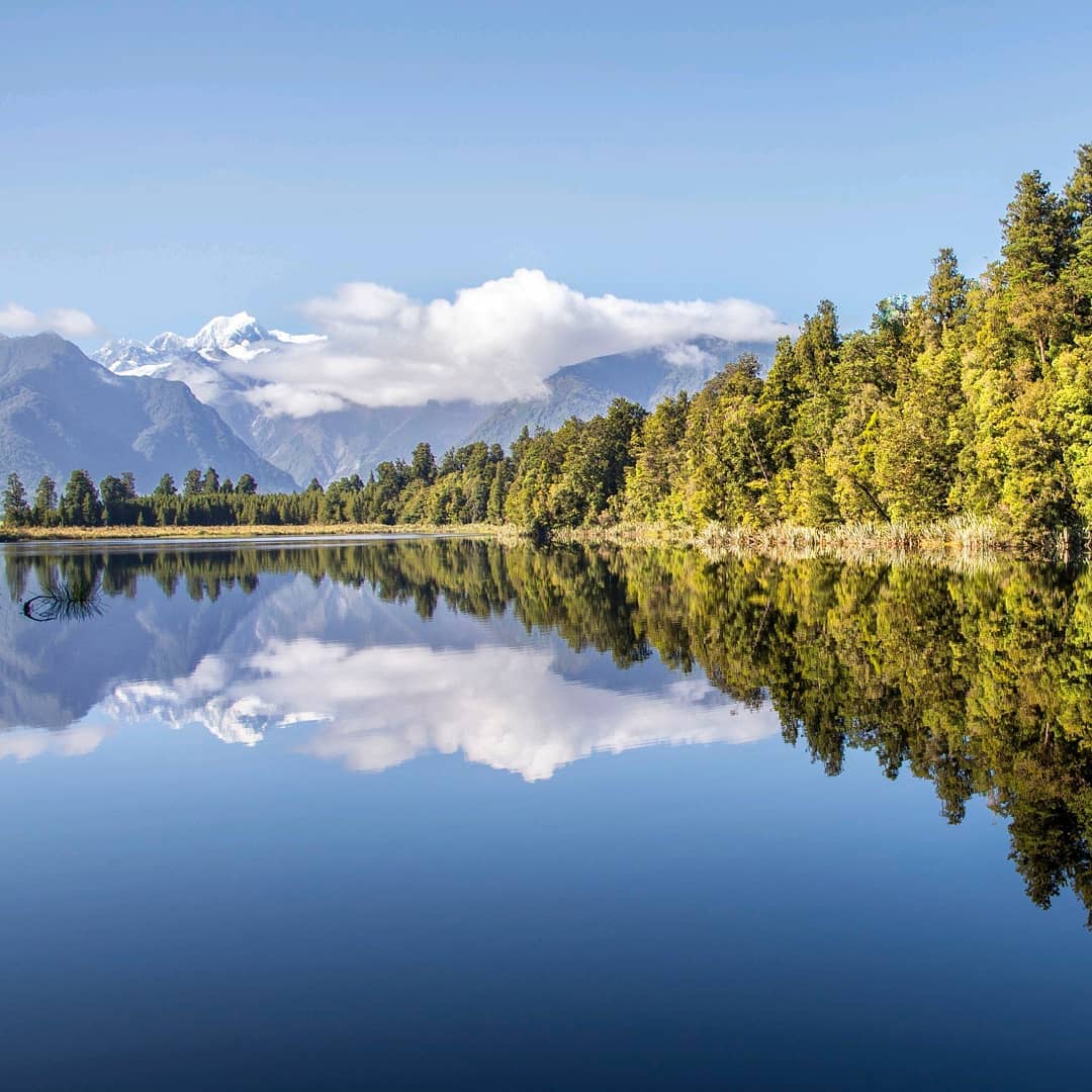 Looking across the still waters of Lake Matheson during our tour of the South Island with @gadventures and @lonelyplanet.⠀⠀
⠀
Our favourite hike on the South Island showcases New Zealand’s highest and second highest mountains. Aoraki / Mount Cook at 3,724m (12,218ft) and Mount Tasman at 3,497m (11,473ft) rise above the calm, reflective waters of Lake Matheson, creating one the most postcard-perfect views in all of New Zealand. ⠀
⠀
Both peaks can be seen mirrored, from all angles, in the serene lake nestled amid lush and ancient forest.⠀
-⠀⠀⠀
-⠀⠀⠀
-⠀⠀⠀
-⠀⠀⠀
-⠀⠀⠀
-⠀⠀⠀
#Aoraki #MountCook #mountcooknz #MountTasman #MtCook #SouthernAlps #Matheson #LakeMatheson #FranzJosef #foxglacier #mountcooknationalpark #southislandnewzealand #southisland #southislandnz #newzealand #NZMustDo #RealMiddleEarth #NZ #visitnewzealand #lpPathfinders #rgphoto #BBCTravel #lonelyplanet #getoutside #gadventures #wellhiked #takeahike
