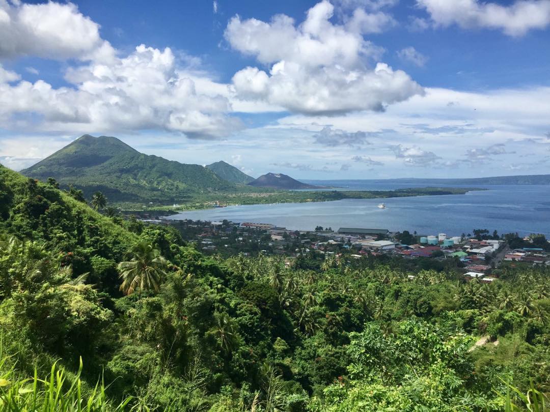Rabaul, Papua New Guinea 🇵🇬.
.
The town of Rabaul taken from the Volcanology Observatory. The three mountains in the background are volcanoes. The smallest mountain to the right, called Tavurvur, erupted in 1994 burying the original town on the far side of the bay under ash. The new town in the foreground has literally risen from the ashes but is still far smaller than the bustling port used to be.
.

#travel #png #png🇵🇬 #enb #eastnewbritain #backpack #volcano #mountain #observatory #rainforest #backpacking #papuanewguinea #rabaul #view #instatravel #traveller