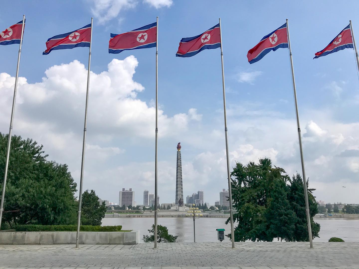 Pyongyang, North Korea 🇰🇵.
.
Looking across the Taedong River to the Juche Tower from Kim Il Sung square. Unfortunately the views from the top of the Juche Tower were covered in cloud when we were there the day before due to the typhoon hitting us. If there is one thing the North Koreans love its very tall flag poles all in a row. 
.
#travel #dprk #korea #pyongyang #traveller #offthebeatenpath #explore #backpacker #travelling #instatravel #northkorea #juchetower #backpacking #travelgram #youngpioneer #travelholic #instaphoto #adventure #northkoreatravel #ypt
